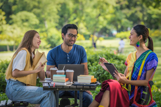 多様なアジアの大学lgbtqの学生クラスメートがチームワークとしてキャンパスパークで一緒にグループ宿題をしているグループ - 人間関係の構築　外 ストックフォトと画像